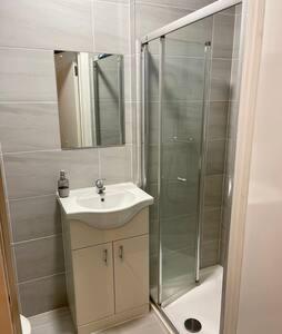a bathroom with a sink and a shower at Luxurious Ensuite in Edgware