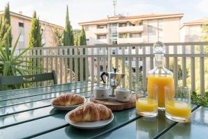 een tafel met 2 borden croissants en jus d'orange bij Shell Apartment - Spazioso Attico Con WiFi Gratuito e Posto Auto in Perugia
