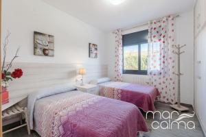 a bedroom with two beds and a window at Villa Ra by MarCalma in Les tres Cales +22 photos