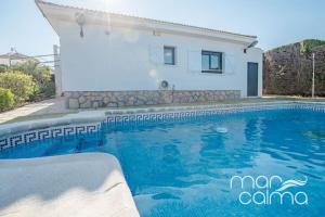 a villa with a swimming pool in front of a house at Villa Ra by MarCalma in Les tres Cales