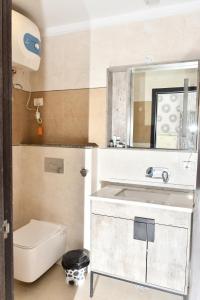 a bathroom with a sink and a toilet and a mirror at Hotel The Heera Divine in Kānpur