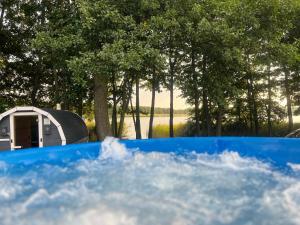 a blue tub in front of a tent and trees at Pasterzewo 20 - domki Mazury in Pasterzewo
