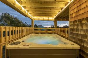 una vasca idromassaggio su una terrazza con tetto di Seaside Serenity Awaits! Luxe Beach Retreat with Hot Tub a Salvo