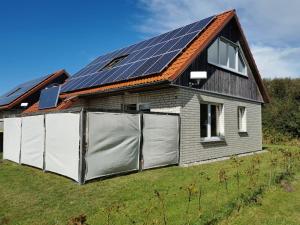 een huis met zonnepanelen op het dak bij Ferienhaus Lille Strandhus in Holnishof