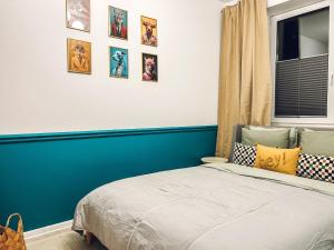 sypialnia z niebieską ścianą z obrazami na ścianie w obiekcie Art Place w Tomaszowie Mazowieckim