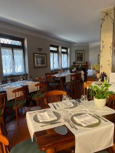 Albergo & Ristorante Selvatico في ريفانازّانو: غرفة طعام مع طاولات وكراسي مع كؤوس للنبيذ