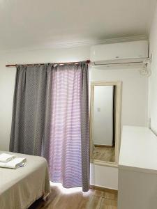 a room with a bed and a window with a mirror at Departamento los hermanos in Concepción del Uruguay