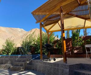 einem Holzpavillon mit einem Tisch und einem Grill in der Unterkunft Refugio Renacer in Pisco Elqui