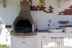 a kitchen with an outdoor oven with a brick wall at Villa Erika with private pool and garden - Happy Rentals in Lecce