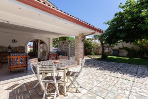 a wooden table and chairs on a patio at Villa Erika with private pool and garden - Happy Rentals in Lecce