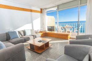 een woonkamer met een bank en een salontafel bij Suitur apartamento frente a la playa de calafell in Calafell