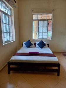 a large bed in a room with two windows at Nature's Nest Kandy in Kandy