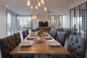 uma sala de jantar com uma mesa longa e cadeiras em Villa KEY WEST & Unique & Piscine & Vue Mer & Clim em Mougins