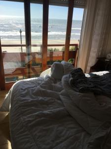 1 cama en un dormitorio con vistas al océano en Semipiso Frente al Mar en San Bernardo