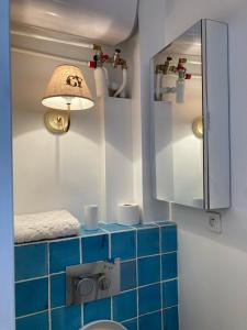 ein Badezimmer mit einer blau gefliesten Theke und einer Lampe in der Unterkunft Saint Sulpice Towers in Paris