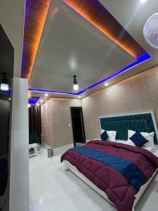 - une chambre avec un lit et une couette violette dans l'établissement As Hotel Expo Inn, à Greater Noida