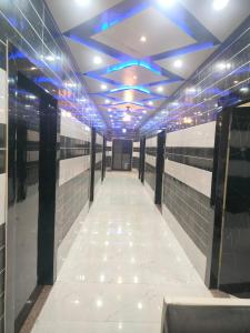 a long hallway with blue lights on the ceiling at As Hotel Expo Inn in Greater Noida