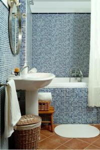 baño de azulejos azules con lavabo y bañera en La Ginesta Rural, cerca de Sitges, en Canyelles