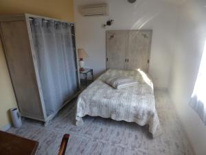 Habitación pequeña con cama y ventana en Chambre d'Hôtes entre Provence et Camargue en Beaucaire