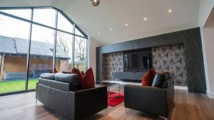 a living room with two chairs and a fireplace at Northumberland Luxury Stays - The Shearling in West Chevington