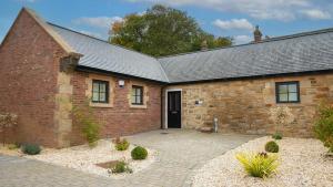a brick building with a driveway in front of it at Northumberland Luxury Stays - The Shearling in West Chevington