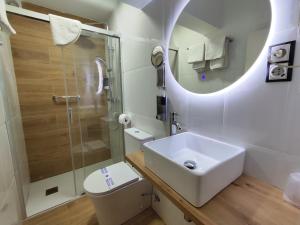 La salle de bains est pourvue d'un lavabo, d'une douche et de toilettes. dans l'établissement Hostal Lucy, à Santander