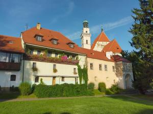 ein Gebäude mit einem Uhrturm im Hintergrund in der Unterkunft Hotel Parkán in Prachatice