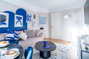 a living room with a couch and a table at Agréable appartement près de la capitale in Neuilly-sur-Seine