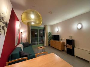 a living room with a green couch and a table at Attico Villaggio Olimpico Sestriere in Sestriere