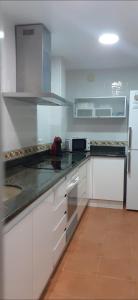 a kitchen with white cabinets and a white refrigerator at Apartamento a 10 metros del mar in Cullera