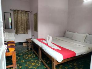 a bed in a room with a red and white blanket at Neev Beach View Goa in Anjuna