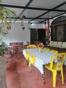 a dining room with a table and yellow chairs at Casa campestre Rancho San Juan in El Pantano
