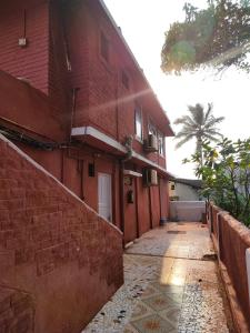 un callejón vacío con un edificio de ladrillo rojo en Neev Beach View Goa en Anjuna