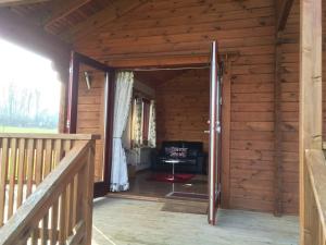 una puerta abierta a una cabaña de madera con una silla en Watermeadow Lakes & Lodges, en North Perrott