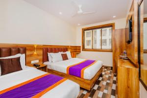 Habitación de hotel con 2 camas y TV en Hotel Era Mumbai en Bombay
