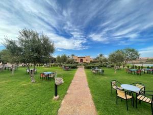 a pathway through a park with tables and chairs at holiday homes ideal for families at IGHIZINN resort in Er Rachidia