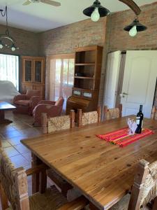 uma sala de jantar com uma mesa de madeira e uma garrafa de vinho em LA QUINTA em Capilla del Señor