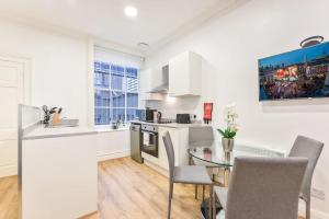 cocina y comedor con mesa y sillas en 2 Bed Piccadilly Apartment- 2, en Londres