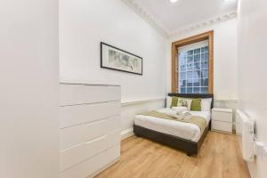 Habitación pequeña con cama y ventana en 2 Bed Piccadilly Apartment- 2, en Londres