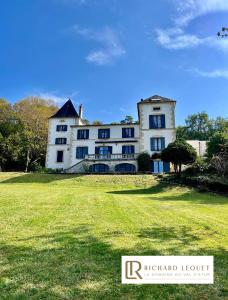 una gran casa blanca con un gran patio en Richard Lequet Domaine gastronomique du Val d Atur en Boulazac