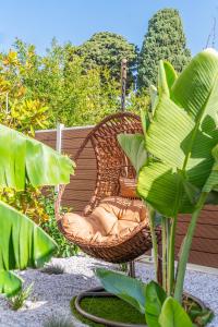 a wicker chair sitting on a patio next to a plant at Samos Tropic Apartments in Ríva
