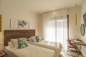 a hotel room with two beds and a window at Samos Tropic Apartments in Ríva