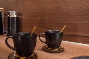 two black cups on a table with chopsticks in them at Samos Tropic Apartments in Ríva