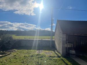 a sunbeam shining on a building with a field in the background at Insolite in Saint-Émiland