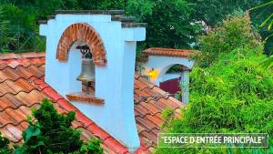 a house with a roof with a bell on it at Villa Merkel - 24 pers - 10 chambr - 9 WC - Art - Piscine in Anglet