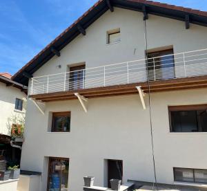 a white house with a balcony at Studio tout confort Annecy in Annecy