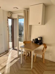 une cuisine avec une table et des chaises ainsi qu'une fenêtre dans l'établissement Studio tout confort Annecy, à Annecy