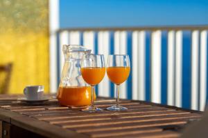 twee glazen sinaasappelsap en een kan op een tafel bij Suitur apartamento frente a la playa de calafell in Calafell