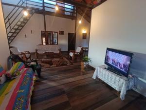 uma sala de estar com uma grande televisão de ecrã plano em Jishi Homestay em Madikeri