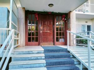 un conjunto de escaleras que conducen a una puerta con adornos navideños en Νέο ανακαινισμένο διαμέρισμα 70τμ στο Μαρούσι, en Atenas